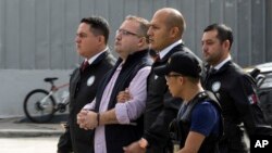 Mexico's ex-governor of Veracruz state, Javier Duarte, is escorted in handcuffs by police to an aircraft as he is extradited to Mexico City, at an Air Force base in Guatemala City, July 17, 2017. 