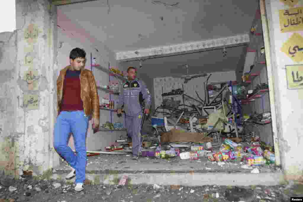 People gather at the site of a car bomb attack in Kirkuk, north of Baghdad, Jan. 15, 2014. 