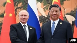 러시아 국영 통신사 스푸트니크가 배포한 이 풀 사진은 지난해 10월 18일 베이징에서 열린 정상회담에서 블라디미르 푸틴 러시아 대통령과 시진핑 중국 주석이 악수하는 모습을 담고 있다.
