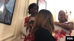 Jacqueline Charles, a reporter at Miami Herald, (on the far left) posts updates to her Twitter feed from the iconic rotating staircase of the Haitian Embassy on October 7, 2018 (Photo: S. Lemaire / VOA)