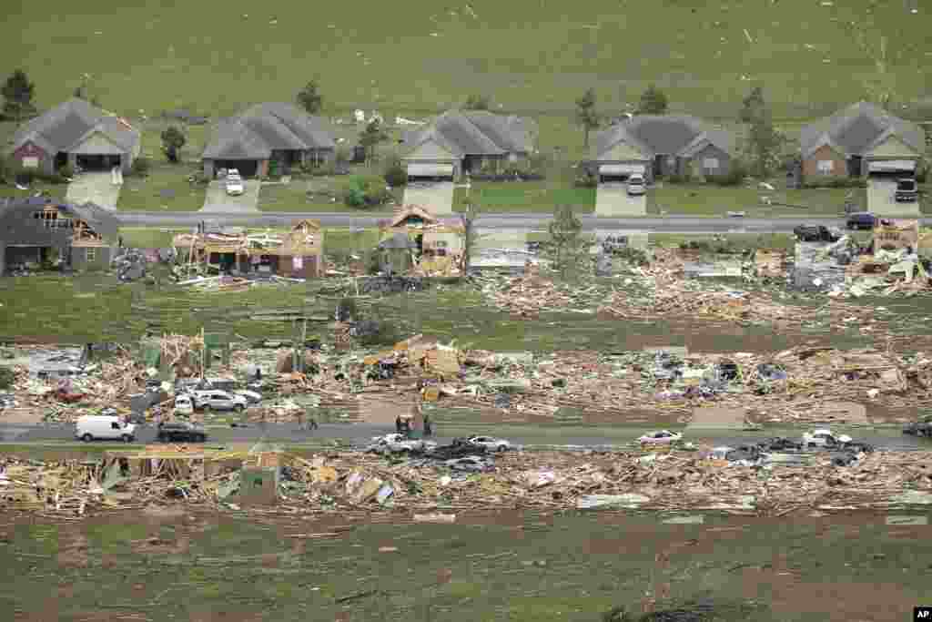 A row of lightly damages houses, top, face a row of destroyed homes after a tornado struck the town killing at least 16 people, Vilonia, Arkansas, April 28, 2014.