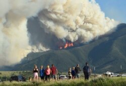 Residents watch as flames from the Robertson Draw fire burn above Red Lodge, Mont., Tuesday evening, June 15, 2021.(Larry Mayer/The Billings Gazette via AP)