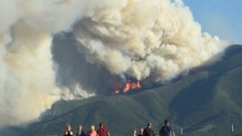 Residents watch as flames from the Robertson Draw fire burn above Red Lodge, Mont., Tuesday evening, June 15, 2021.(Larry Mayer/The Billings Gazette via AP)