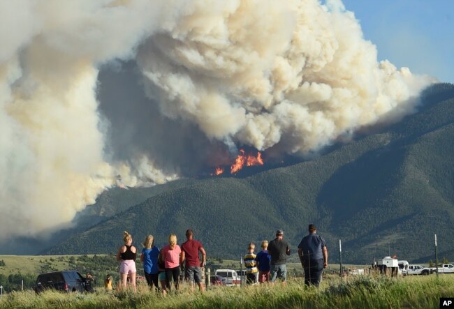 Moradores observam as chamas do fogo Robertson Draw queimar acima de Red Lodge, Mont., Terça-feira à noite, 15 de junho de 2021. (Larry Mayer / The Billings Gazette via AP)