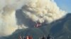 Para warga melihat api yang berkobar membakar area di ataa Red Lodge, Montana, pada 15 Juni 2021.(Larry Mayer/The Billings Gazette via AP)
