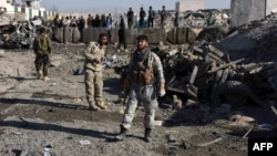Afghan security personnel gather at the site of a suicide attack at a police compound in Maiwand district of Kandahar province on December 22, 2017.