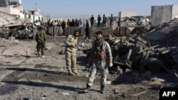 Afghan security personnel gather at the site of a suicide attack at a police compound in Maiwand district of Kandahar province on December 22, 2017.