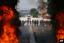 FILE - Bolivarian National Guard troops man a barricade blocking access to the Francisco De Paula Santander international bridge in Urena, Venezuela, on the border with Colombia, Feb. 23, 2019.