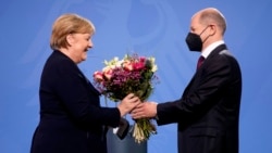 New elected German Chancellor Olaf Scholz, right, gives flowers to former Chancellor Angela Merkel during a handover ceremony in the chancellery in Berlin, Wednesday, Dec. 8, 2021. (Photo/Markus Schreiber)