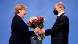 New elected German Chancellor Olaf Scholz, right, gives flowers to former Chancellor Angela Merkel during a handover ceremony in the chancellery in Berlin, Wednesday, Dec. 8, 2021. (Photo/Markus Schreiber)