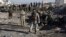 Afghan security personnel gather at the site of a suicide attack at a police compound in Maiwand district of Kandahar province on December 22, 2017.