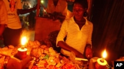 A Ugandan woman shops at a kiosk in candle light in Kampala. (file photo)