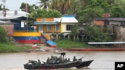 Soldados de la Armada venezolana patrullan el río Arauca, la frontera natural con Colombia, visto desde Arauquita, Colombia. Marzo 26, 2021.