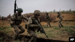 En esta fotografía proporcionada por el servicio de prensa, los militares ucranianos recién reclutados mejoran sus habilidades tácticas en una carrera de obstáculos en el campo de entrenamiento en la región de Donetsk, Ucrania, el 14 de octubre de 2024. [Foto: Archivo/Vía AP]