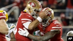 San Francisco 49ers running back Raheem Mostert, right, celebrates his touchdown with quarterback Jimmy Garoppolo during the second half of the NFL NFC Championship football game against the Green Bay Packers Sunday, Jan. 19, 2020, in Santa Clara, Calif. 