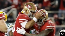 San Francisco 49ers running back Raheem Mostert, right, celebrates his touchdown with quarterback Jimmy Garoppolo during the second half of the NFL NFC Championship football game against the Green Bay Packers Sunday, Jan. 19, 2020, in Santa Clara, Calif. 