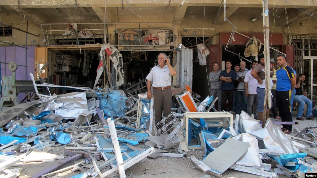 Residents stand among debris at one of the scenes of car bomb attacks that struck three mainly Shi'ite districts in Iraq's capital, Baghdad, July 19, 2014. A suicide bomber struck earlier in the day.