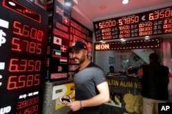 FILE - A man walks out of a currency exchange shop in Istanbul, Aug. 16, 2018.