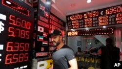 Seorang pria berjalan keluar dari tempat penukaran mata uang asing di Istanbul, 16 Agustus 2018.