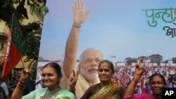 Supporters of India's ruling Bharatiya Janata flash victory signs as they celebrate outside their party office in Mumbai, India, Oct. 24, 2019.