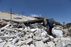 FILE - A man looks through the rubble of a destroyed house in the village of Iblin in the Jabal al-Zawiya region in Syria's rebel-held northwestern Idlib province, June 10, 2021, following reported bombardment by government forces.