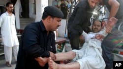 Seorang korban luka-luka akibat ledakan bom di sebuah masjid di Malakand, Khyber Pakhtunkhwa, sebelum dilarikan ke rumah sakit di Peshawar, Pakistan (17/5). 