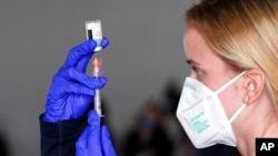 FILE - Registered nurse Katherine Ambrose draws some Moderna COVID-19 vaccine to give to people at a Sacramento County drive-thru vaccination center, in Sacramento, Calif., Jan. 21, 2021. 