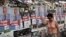 A woman walks past pre-election posters in Athens June 16, 2012. Greece holds general parliamentary elections on June 17. 
