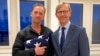 FILE - In this image provided by the U.S. State Department, Michael White holds an American flag as he poses for a photo June 4, 2020, with U.S. special envoy for Iran Brian Hook at the Zurich, Switzerland, airport after White’s release from Iran.