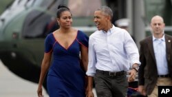 Presiden AS Barack Obama dan ibu negara Michelle Obama di bandar udara Matha's Vineyard di West Tisbury, Massachusetts (6/8). (AP/Manuel Balce Ceneta) 