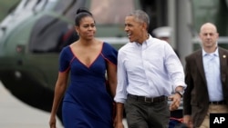 President Barack Obama and first lady Michelle Obama walk on the tarmac at Matha's Vineyard Airport in West Tisbury, Mass., Aug. 6, 2016. The president and his family are vacationing in the Massachusetts island of Martha's Vineyard. 