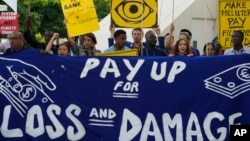 FILE - Activists participate in a demonstration for the loss and damage fund at the COP28 U.N. Climate Summit, Dec. 6, 2023, in Dubai, United Arab Emirates.