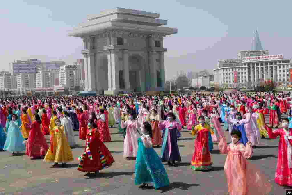 Mulheres dançam perto do Arco do Triunfo no Dia do Sol, aniversário de nascimento do falecido líder Kim Il Sung, em Pyongyang, Coreia do Norte, 15 de Abril de 2021. (AP Photo / Jon Chol Jin)