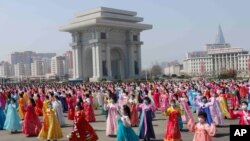 Women dance near the Arch of Triumph on the Day of the Sun, the birth anniversary of late leader Kim Il Sung, in Pyongyang, North Korea, April 15, 2021.