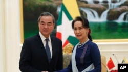 Myanmar's de facto civilian leader Aung San Suu Kyi, right, shakes hands with Chinese Foreign Minister Wang Yi, left, during their meeting at the President House in Naypyitaw, Myanmar, Dec. 7, 2019.
