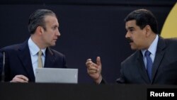 El presidente de Venezuela, Nicolás Maduro (derecha) habla con el vicepresidente de Venezuela, Tareck El Aissami, mientras asisten al evento de lanzamiento de la nueva criptomoneda venezolana "petro" en Caracas, Venezuela, el 20 de febrero de 2018. aRCHIVO.