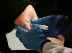 File - A woman receives a measles, mumps and rubella vaccine at the Rockland County Health Department in Pomona, N.Y., north of New York City, March 27, 2019.