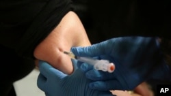 File - A woman receives a measles, mumps and rubella vaccine at the Rockland County Health Department in Pomona, N.Y., north of New York City, March 27, 2019.