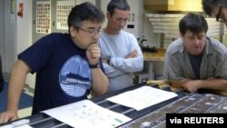 Researchers, from left, Yuki Morono, Laurent Toffin and Steven D’Hondt work aboard the research drillship JOIDES Resolution with sediment cores gathered from beneath the sea floor under the Pacific Ocean in this undated photo released July 28, 2020.