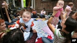 Parents and their infant children enjoy a music appreciation and therapy lesson held by parent Randi Madrid at her home in the Queens borough of New York, Monday, Oct. 12, 2008. (AP Photo/Craig Ruttle)