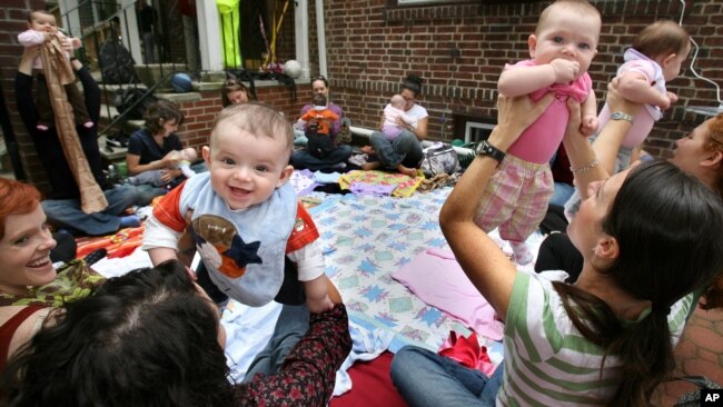 Parents and their infant children enjoy a music appreciation and therapy lesson held by parent Randi Madrid at her home in the Queens borough of New York, Monday, Oct. 12, 2008. (AP Photo/Craig Ruttle)