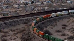 FILE  - A train travels along the U.S. side close to a portion of the border wall along the U.S.-Mexico border between Cuidad Juarez, Mexico and Sunland Park, New Mexico, as seen from Mount Cristo Rey in El Paso, Texas. 
