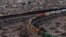 A train travels along the US side close to a portion of the border wall along the U.S.-Mexico border between Cuidad Juarez, Mexico and Sunland Park, New Mexico, as seen from Mount Cristo Rey in El Paso, Texas, Feb. 26, 2025. 