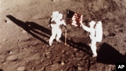 Apollo 11 astronauts Neil Armstrong and Edwin "Buzz" Aldrin, the first men to land on the moon, plant the U.S. flag on the lunar surface on July 20, 1969
