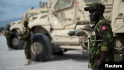 (FILE) A Kenyan member of the Multinational Security Support Mission stands next to a Maxxpro Mine Resistant Ambush Protected Vehicle in Port Au Prince, Haiti on September 05, 2024.