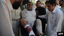 Pakistani paramedics shift an injured man into the hospital after a suicide blast in Mardan at the gathering of funeral prayers, in Peshawar, June 18, 2013.