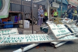 Polisi membongkar papan nama di markas besar organisasi garis keras Indonesia FPI di Jakarta pada 30 Desember 2020, setelah pemerintah melarang kelompok itu melakukan kegiatan apa pun. (Foto: AFP)