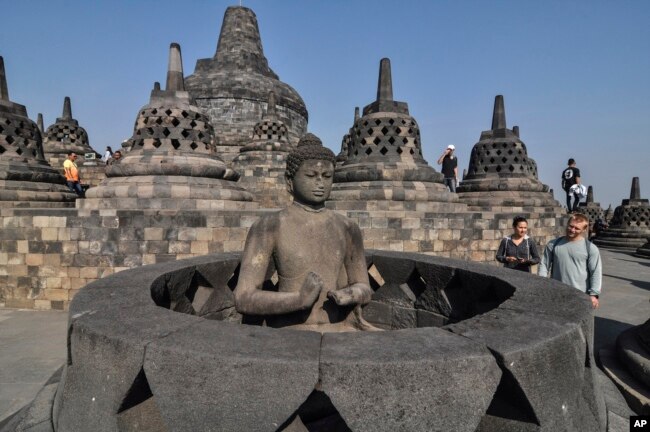 Para turis melihat-lihat patung Buddha di Candi Prambanan di Magelang, Jawa Tengah, 12 Agustus 2019. (Foto: AP/Slamet Riyadi)