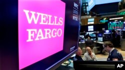 FILE - The Wells Fargo logo appears above a trading post on the floor of the New York Stock Exchange, Feb. 7, 2018. 
