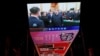 A giant screen at a shopping mall in Beijing shows news footage of Chinese leader Xi Jinping shaking hands with Alibaba founder Jack Ma at a private enterprise forum, Feb. 17, 2025. 